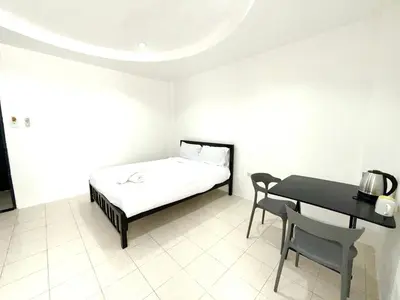 a bedroom with a bed and a table and chairs at Patong Canal Villa 108 in Patong Beach