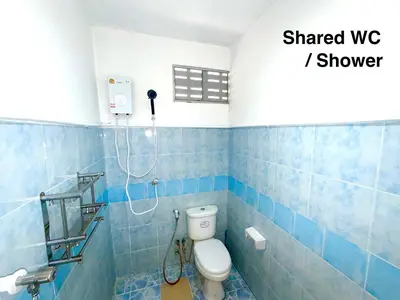 a blue tiled bathroom with a toilet and a shower at Patong Canal House 1 in Patong Beach