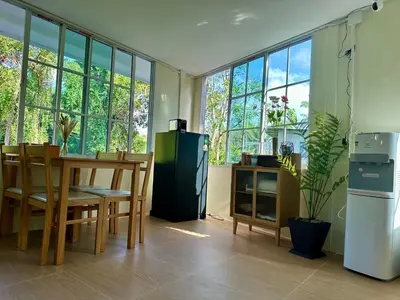 a dining room with a table and chairs and windows at Sweed Dee Love Hostel in Phi Phi Don