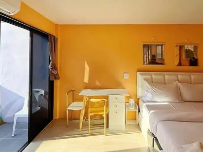 a bedroom with a bed and a desk and a table at \u82ad\u4e1c\u6d77\u6ee9\u5fc3\u6f84\u9152\u5e97 in Patong Beach