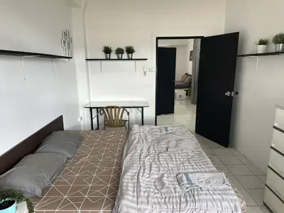 a bed in a room with a table and a tableablish at Bestin Karon1 - 1 min from the beach, pet friendly TF in Karon Beach