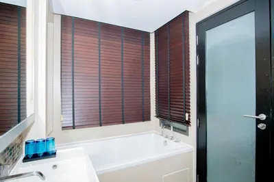 a bathroom with a tub and a large window at Beachfront Family Pool 2 Bed Room Patong Phuket in Patong Beach