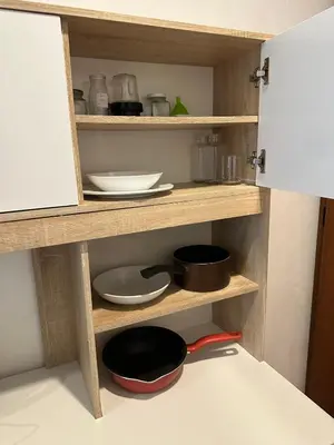 a kitchen with wooden shelves with bowls and pans at Bestin Karon 2 in Karon Beach