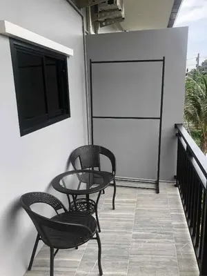 a patio with two chairs and a table on a balcony at Borrii House โบ ลี่ เฮาท์ in Layan Beach