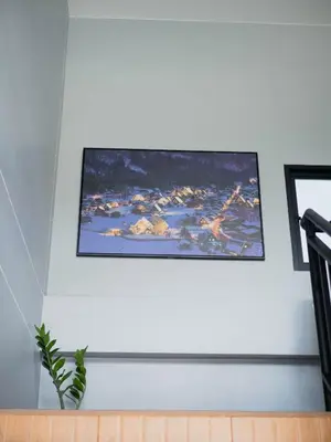 a painting hanging on a white wall with a picture at Borrii House โบ ลี่ เฮาท์ in Layan Beach