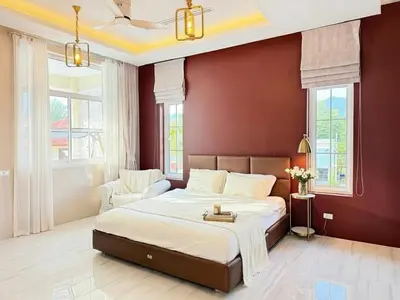 a bedroom with a large bed with red walls at Kamala Beach Phuket - 4BR Private Luxury Pool Villa with Maid in Kamala Beach