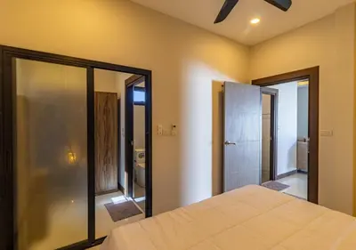 a bedroom with a large bed and a bathroom at Villa Junia - Quiet 3-bedroom Pool Villa in Ban Saiyuan (1)