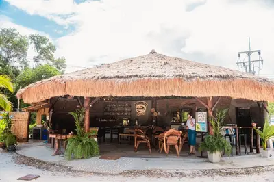 a restaurant with a straw umbrella and tables and chairs at Laleuca At Laemhad Kohyaoyai in Ko Yao Yai