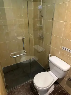 a bathroom with a toilet and a glass shower at Bestin Kata in Karon Beach