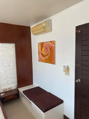 a room with a bench and a painting on the wall at Bestin Kata in Karon Beach