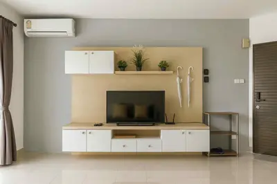a living room with a flat screen tv on a cabinet at Supalai Park Phuket City 2 bedrooms for rent in Phuket Town