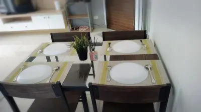 a table with four chairs and a table with white plates on it at Supalai Park Phuket City 2 bedrooms for rent in Phuket Town