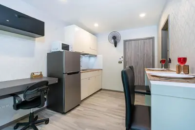 a kitchen with a counter and a refrigerator and a table at 1 br Cozy Orchid at The Title Nai Yang in Nai Yang Beach