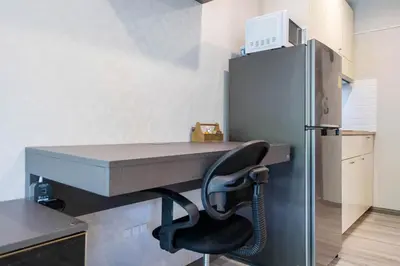 a desk with a chair next to a refrigerator at 1 br Cozy Orchid at The Title Nai Yang in Nai Yang Beach