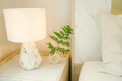 a lamp on a night stand next to a bed at Strelitzia Tropical Living at Title Nai Yang in Nai Yang Beach
