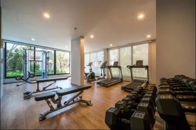 a gym with several treadmills and elliptical machines at Strelitzia Tropical Living at Title Nai Yang in Nai Yang Beach