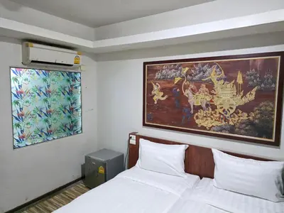 a bedroom with a bed and a large painting on the wall at Le Moon in Patong Beach