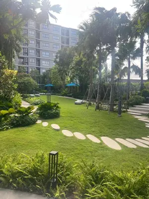 a park with palm trees and a large building at Luxury cosy condo in Kathu centre in Kathu