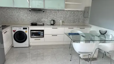 a kitchen with a glass table and a washing machine at Modern Kamala Townhouse Hideaway with Shared Pool in Kamala Beach