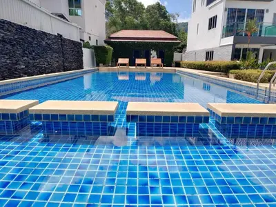 a large swimming pool with blue tiles on it at Modern Kamala Townhouse Hideaway with Shared Pool in Kamala Beach
