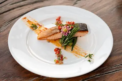 a white plate with fish and vegetables on a table at Villa Serenity -30 meter Pool & 6 Bedroom with Cinema Room and Gym in Ko Lek