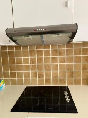 a stove top in a kitchen with brown tiles at The President Park Condo Nanai, Patong, Phuket in Patong Beach