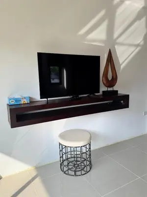 a living room with a stool and a tv on a wall at The President Park Condo Nanai, Patong, Phuket in Patong Beach