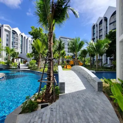 a palm tree next to a swimming pool at a resort at Title Halo Nai Yang Тайтл Хало Най Янг operated by OK Group in Nai Yang Beach