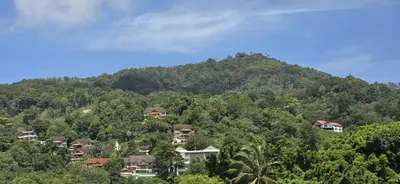 a group of houses on a hill in front of a mountain at APK Hillview Hotel in Patong Beach