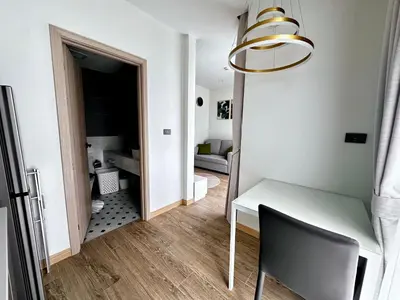 a dining room with a white table and a chair at Palmetto Park Condominium in Karon Beach