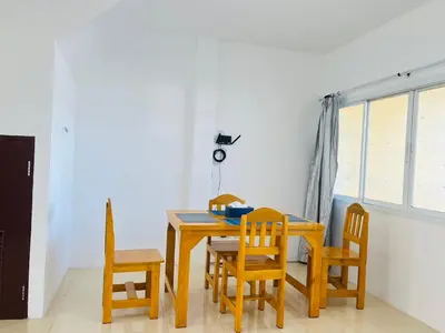 a dining room with a table and chairs and a window at Winlee house in Ban Phlu Yai
