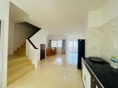 a living room with a staircase in a house at Winlee house in Ban Phlu Yai