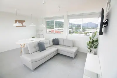a white living room with a couch and a table at Spacious 2 Bedrooms 360deg Mountain-View Apartment in Ban Klang