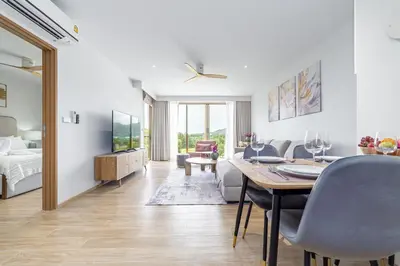 a living room with a dining room table and a bedroom at Beachside 1 bedroom apartment 200 meters to Bang Tao Beach Manage by OCEAN HUB in Ban Thalat Choeng Thale
