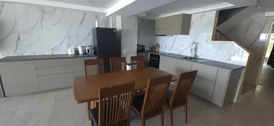 a kitchen with a wooden table and chairs in it at Andaman Seaview house rooftop 2 in Patong Beach