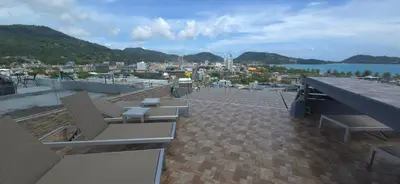 a balcony with chairs and a view of a city at Andaman Seaview house rooftop 2 in Patong Beach