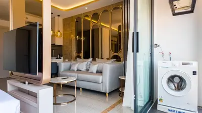 a living room with a couch and a tv at Apartment studio in Bellevue Lagoon on Bang Tao in Laguna Phuket