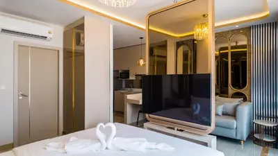 a room with a bed and a tv and a living room at Apartment studio in Bellevue Lagoon on Bang Tao in Laguna Phuket