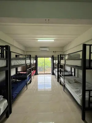 a room with several bunk beds and a window at Klong Muang Hostel คลองม่วงโฮสเทล in Ban Ko Kwang