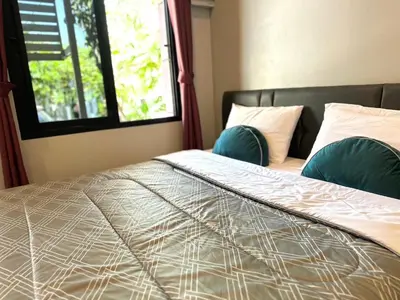 a bedroom with a large bed with a window at Saiinam Laguna Inn in Ban Thalat Choeng Thale