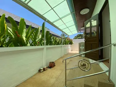 a balcony with a door and some plants at Villa Jasmine in Rawai Beach