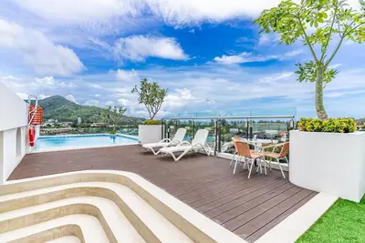 a deck with chairs and a swimming pool at Fantasea by Villacarte in Kamala Beach