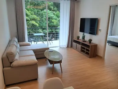 a living room with a couch and a tv at Kamala falls seaview 1 bedroom in Phuket Town