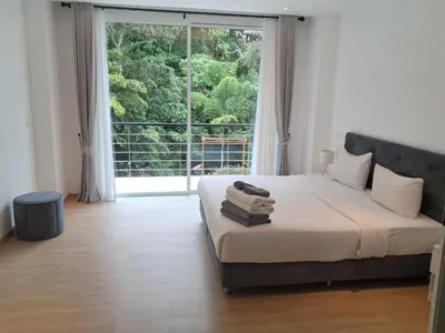 a bedroom with a bed with a large window at Kamala falls seaview 1 bedroom in Phuket Town