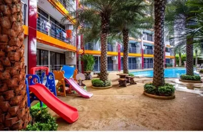 a playground with slides and palm trees in a building at Lux apartment Mai Khao beach in Mai Khao Beach