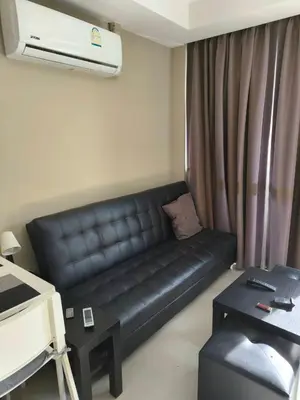 a living room with a black leather couch in a room at Lux apartment Mai Khao beach in Mai Khao Beach