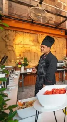 a man in a chefs hat standing in a kitchen at Lux apartment Mai Khao beach in Mai Khao Beach