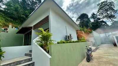 a motorcycle parked in front of a house at Villa avec piscine privée in Kamala Beach