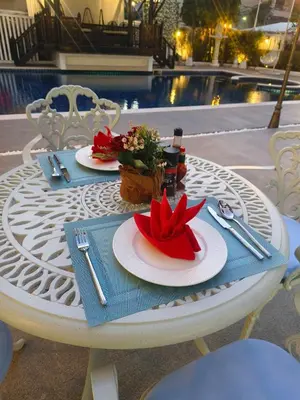 a white table with two plates of food on it at Villa Atchara in Patong Beach