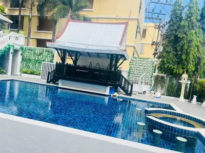 a swimming pool with a gazebo next to a building at Villa Atchara in Patong Beach